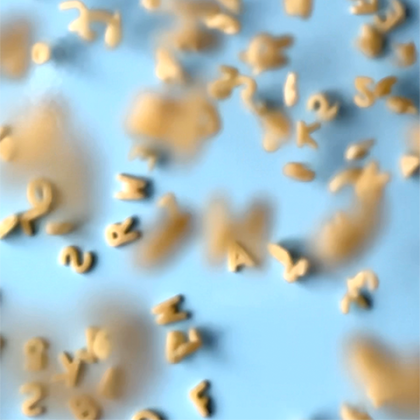 Kreisrundes Foto mit herabfallenden Buchstabensuppen in der Luft auf hellblauen Hintergrund